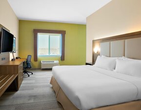 Comfortable king bedroom with TV and business desk at Holiday Inn Express & Suites Ontario.