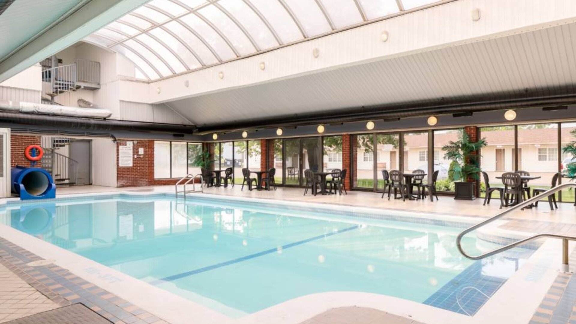 The hotel’s indoor pool features a slide, and has nearby tables and chairs.
