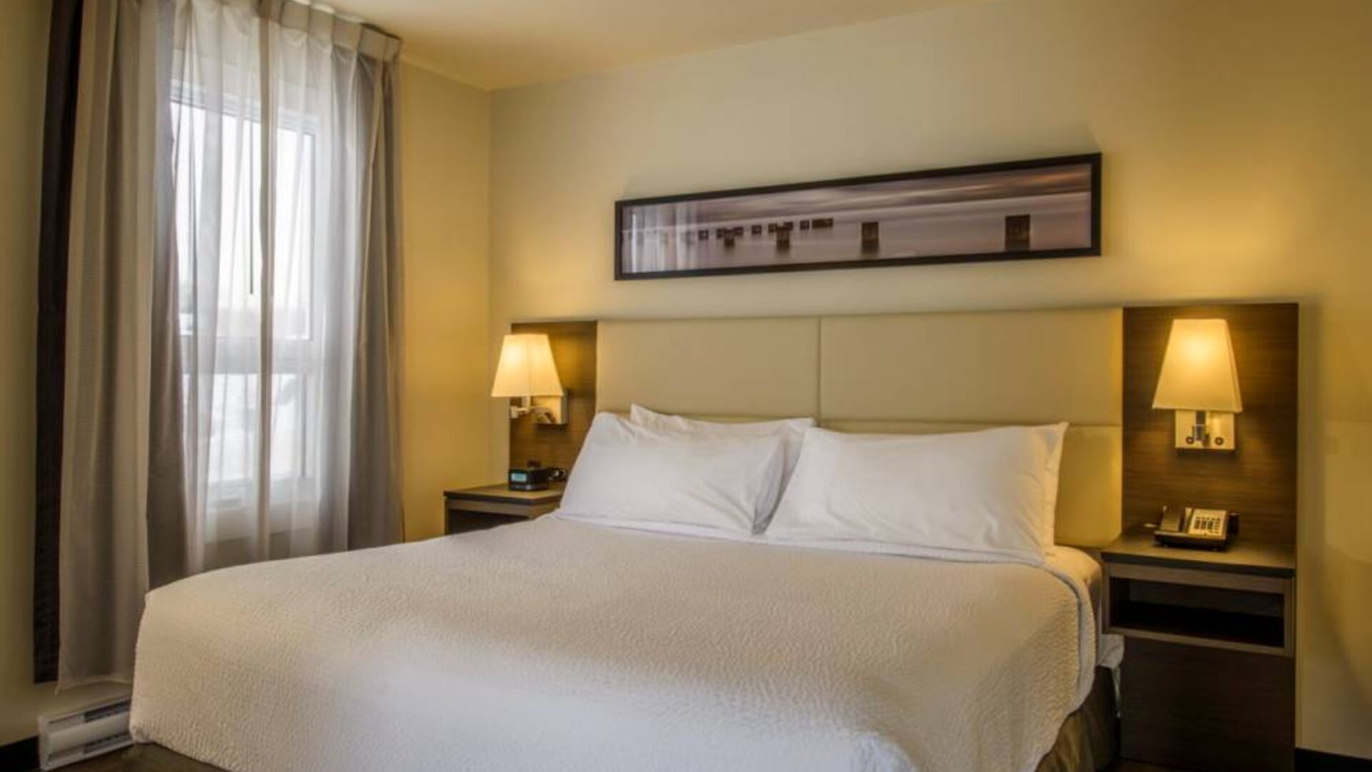 Double bed guest room in Rodd Miramichi River, with bedside lamps and nearby window.