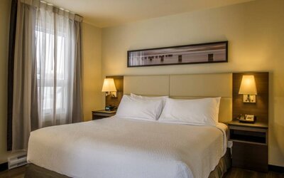 Double bed guest room in Rodd Miramichi River, with bedside lamps and nearby window.