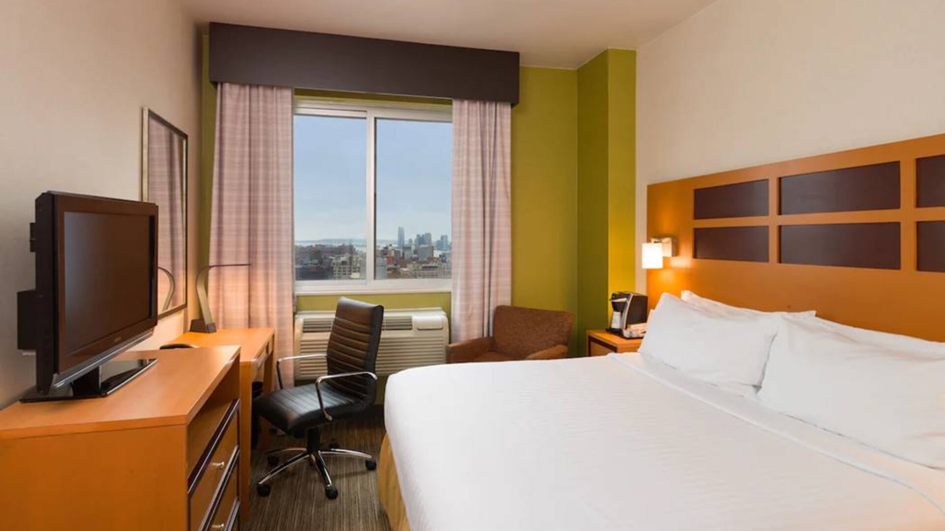 Guest room of the Holiday Inn Express Times Square, with double bed, window, TV, and desk.