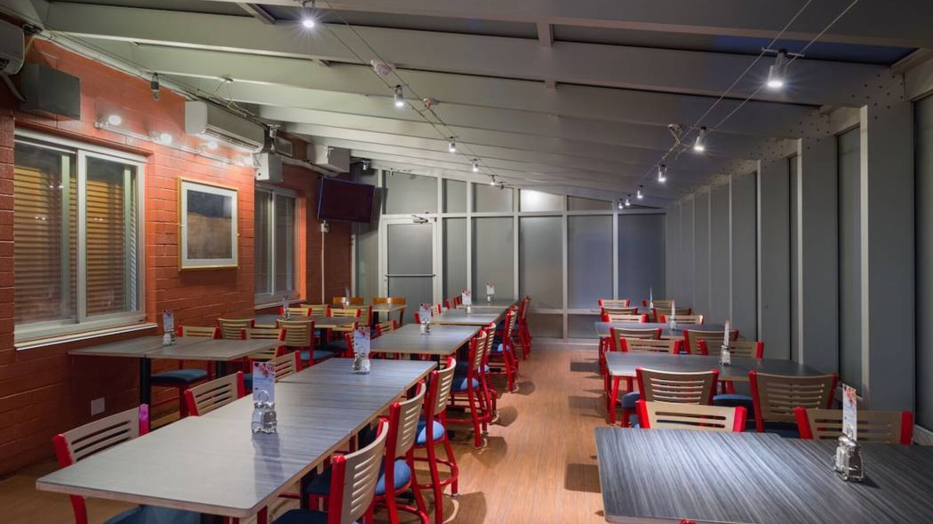 The hotel’s breakfast area, which has a hard floor and tables for four or more diners.