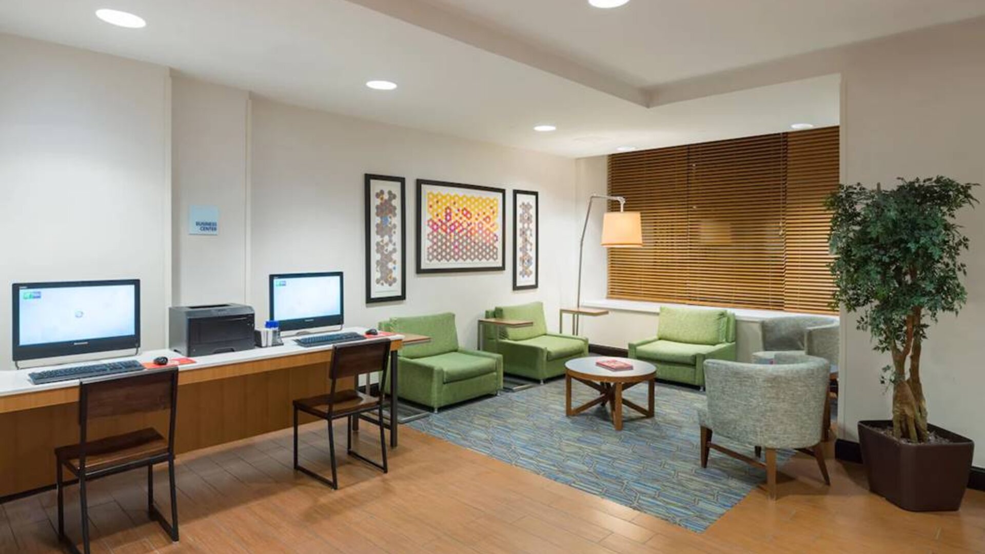 The Holiday Inn Express Times Square’s lounge, with comfy chairs, coffee table, and two workstations.