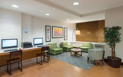 The Holiday Inn Express Times Square’s lounge, with comfy chairs, coffee table, and two workstations.