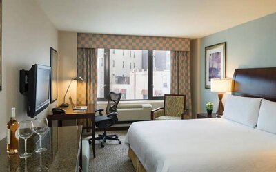 Guest room in the Hilton Garden Inn Tribeca, furnished with large bed, desk and chair for working, and TV.
