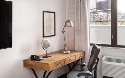An in-room work station at the Hilton Garden Inn Tribeca, with lamp, chair, and desk.