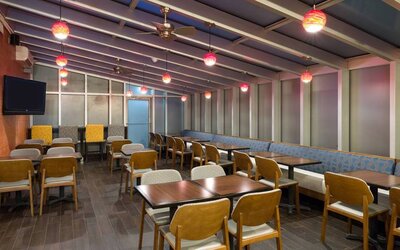 The hotel’s breakfast area, with hard floor and tables for two or four diners.