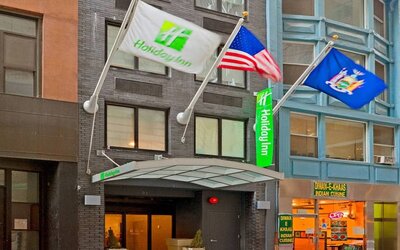 Exterior shot of the Holiday Inn Express Wall Street and its trio of fluttering flags.