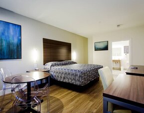 Day use room with dining table, work desk and TV at Palace Inn Blue Gessner.