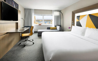 Spacious day use room with TV, business desk, and couch at M Social Hotel Times Square.

