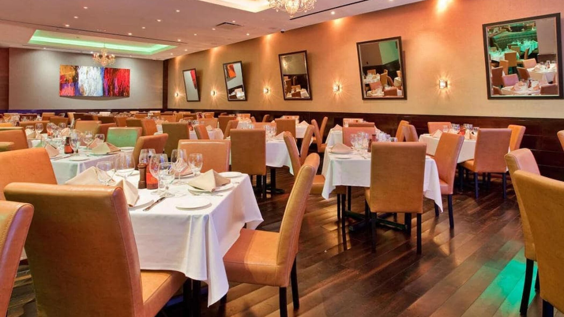 Empire Steak House, the hotel’s on-site restaurant, with small tables and hard floor.