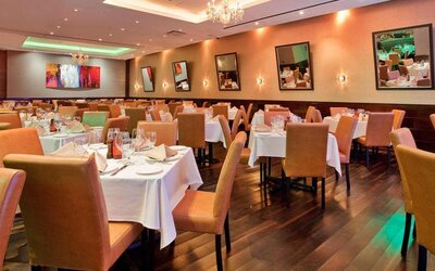 Empire Steak House, the hotel’s on-site restaurant, with small tables and hard floor.