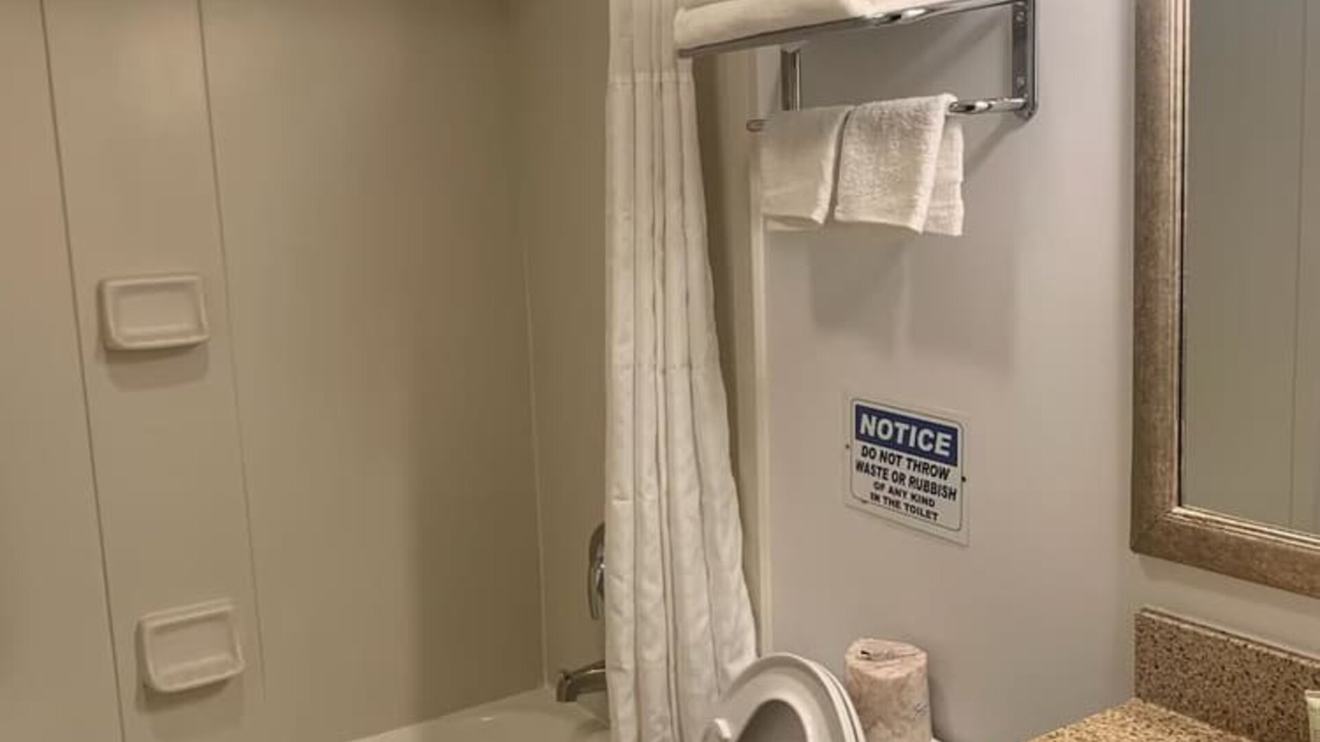 Guest bathroom with shower and tub at Sky Hotel Flushing - Laguardia Airport.