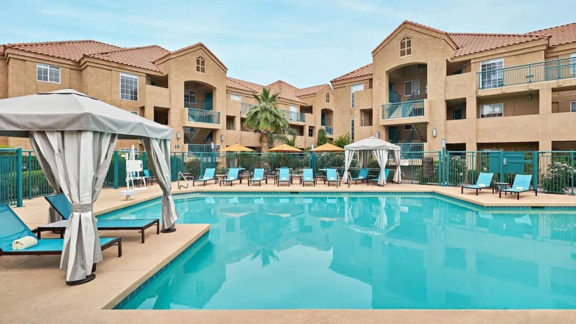 Lovely outdoor pool with cabanas and pool chairs at Hyatt House Scottsdale.