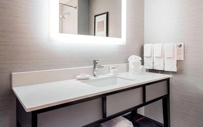 Guest bathroom with shower at Courtyard By Marriott Boston Brookline.