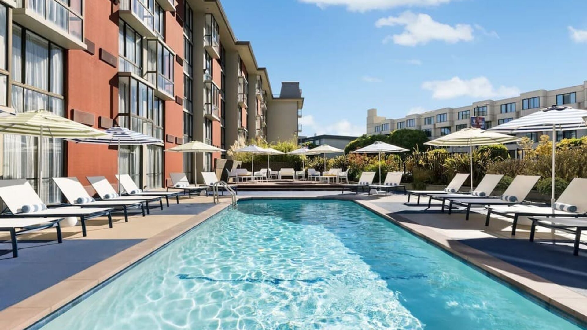 Stunning outdoor pool with sun beds and umbrellas at Hotel Caza.