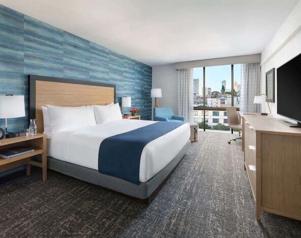 King bedroom with lots of natural light and work desk at Hotel Caza.