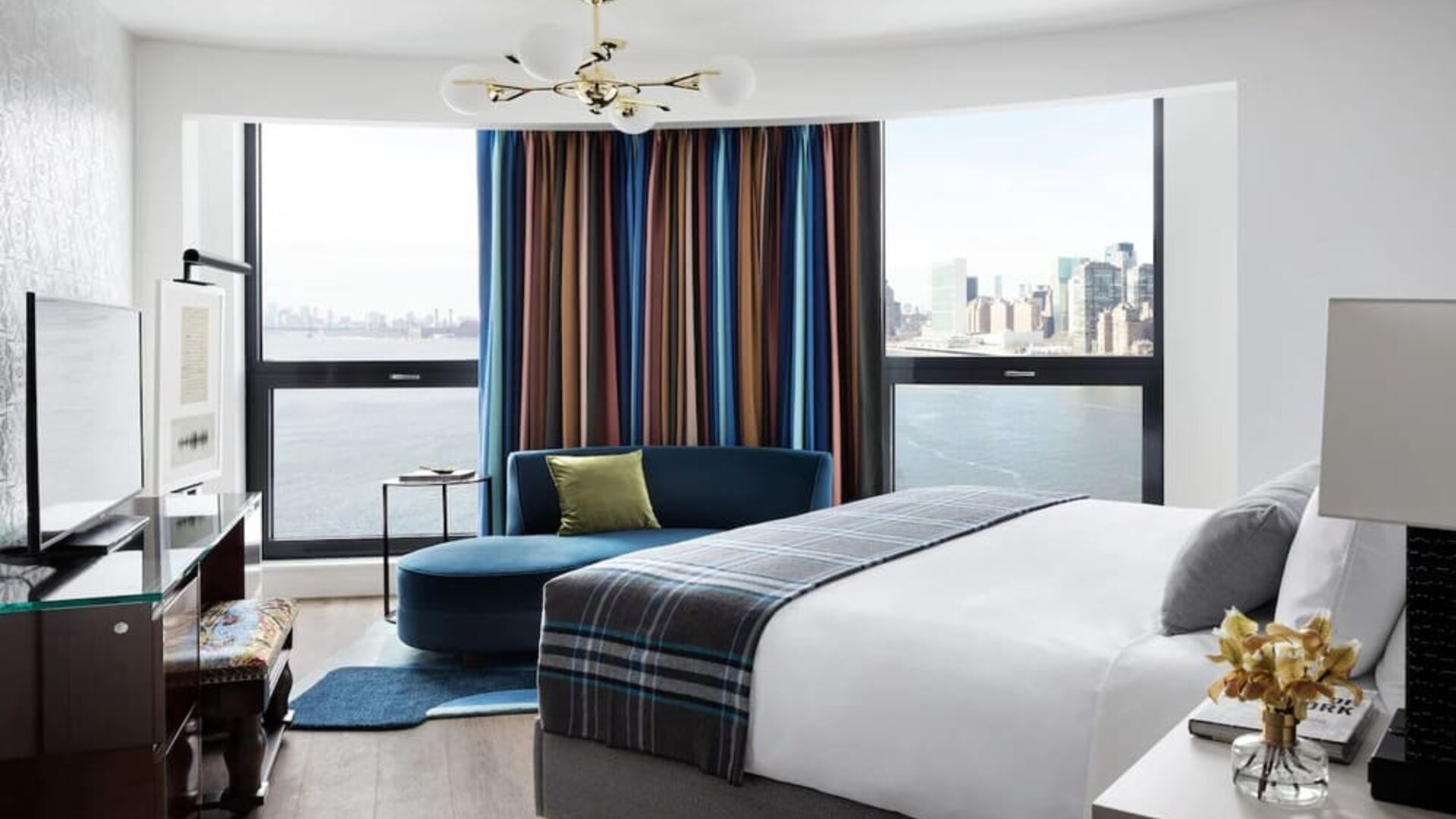 Spacious king bed with TV and seating area at Graduate New York.