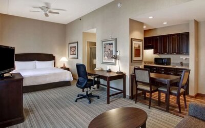Spacious king bed with business desk at Homewood Suites By Hilton Burlington.