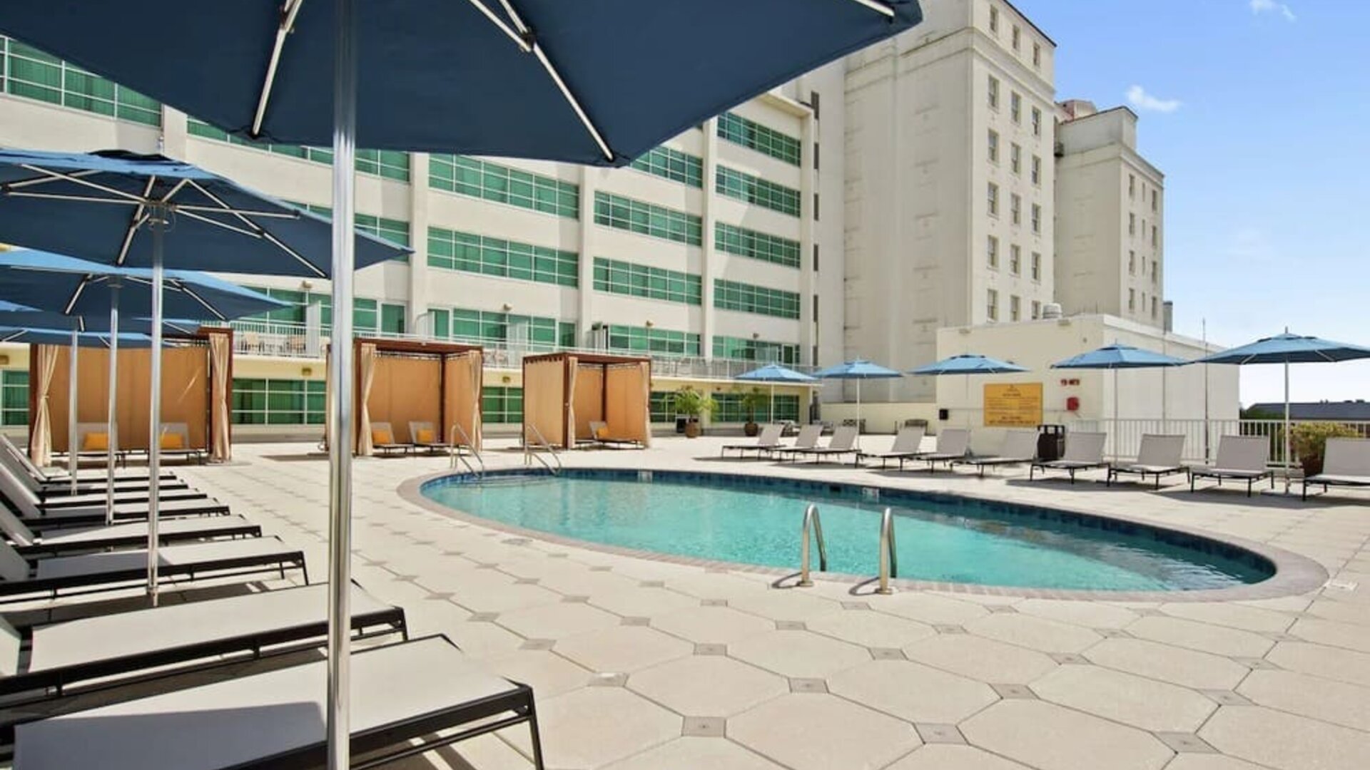 Stunning outdoor pool with pool chairs at Hilton Baton Rouge Capitol Center.