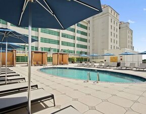 Stunning outdoor pool with pool chairs at Hilton Baton Rouge Capitol Center.