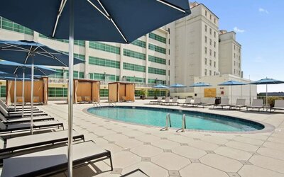 Stunning outdoor pool with pool chairs at Hilton Baton Rouge Capitol Center.
