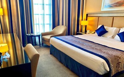 King bed with natural light at Millennium Central Doha.