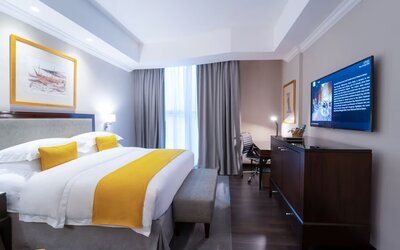 King bed with TV at Millennium Hotel Doha.