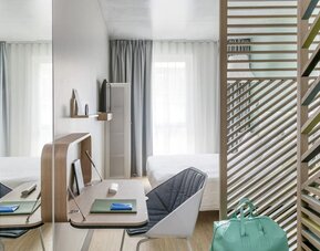 King bed with natural light at OKKO Hotels Nice Aéroport.