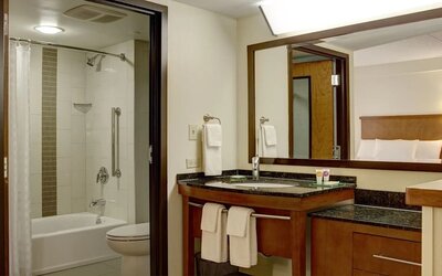 Guest bathroom with shower and tub at Hyatt Place Fort Lauderdale Cruise Port.