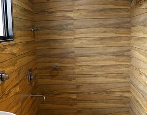 Guest bathroom with shower and towels at Hotel Alka Residency.