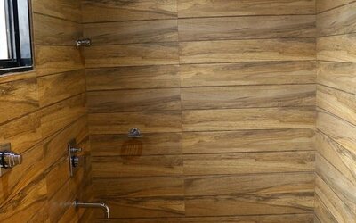 Guest bathroom with shower and towels at Hotel Alka Residency.