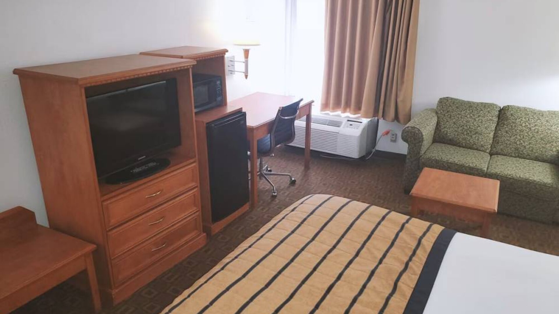 Sofa, work desk and TV inside day use room of the Coratel Inn & Suites By Jasper New Braunfels IH-35 EXT 189.