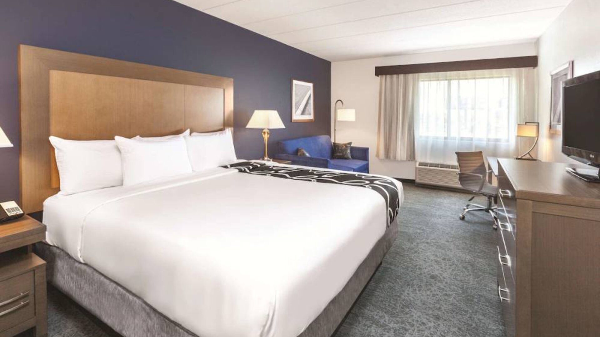 Day use room with work desk and sofa at La Quinta Inn & Suites By Wyndham Philadelphia Airport.
