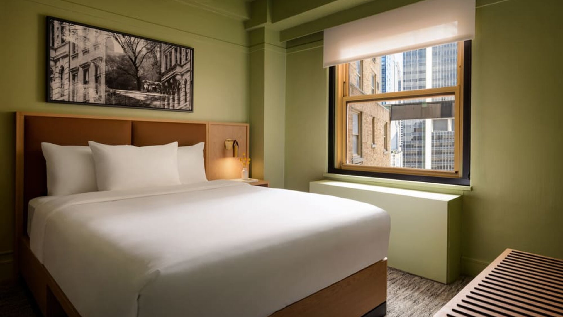 Guest room with natural light, city views, and minimalist modern furnishings at Row NYC.
