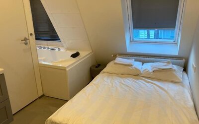 Cozy guest room with a double bed, whirlpool bathtub, skylight window, and fresh linens at Hotel Chao 24/7.