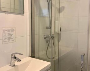Modern bathroom featuring a glass-enclosed shower, vanity sink, and contemporary fixtures at Hotel Chao 24/7.