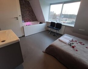 Spacious suite with whirlpool bathtub, seating area, large windows, and comfortable accommodations at Hotel Chao 24/7.