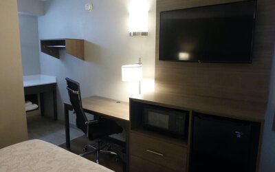 Day room with TV and work desk at Red Roof Plus Bourbonnais.