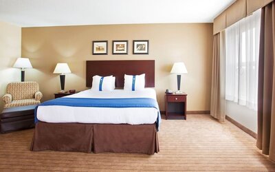 delux king room with couch at Holiday Inn Aurora North- Naperville.