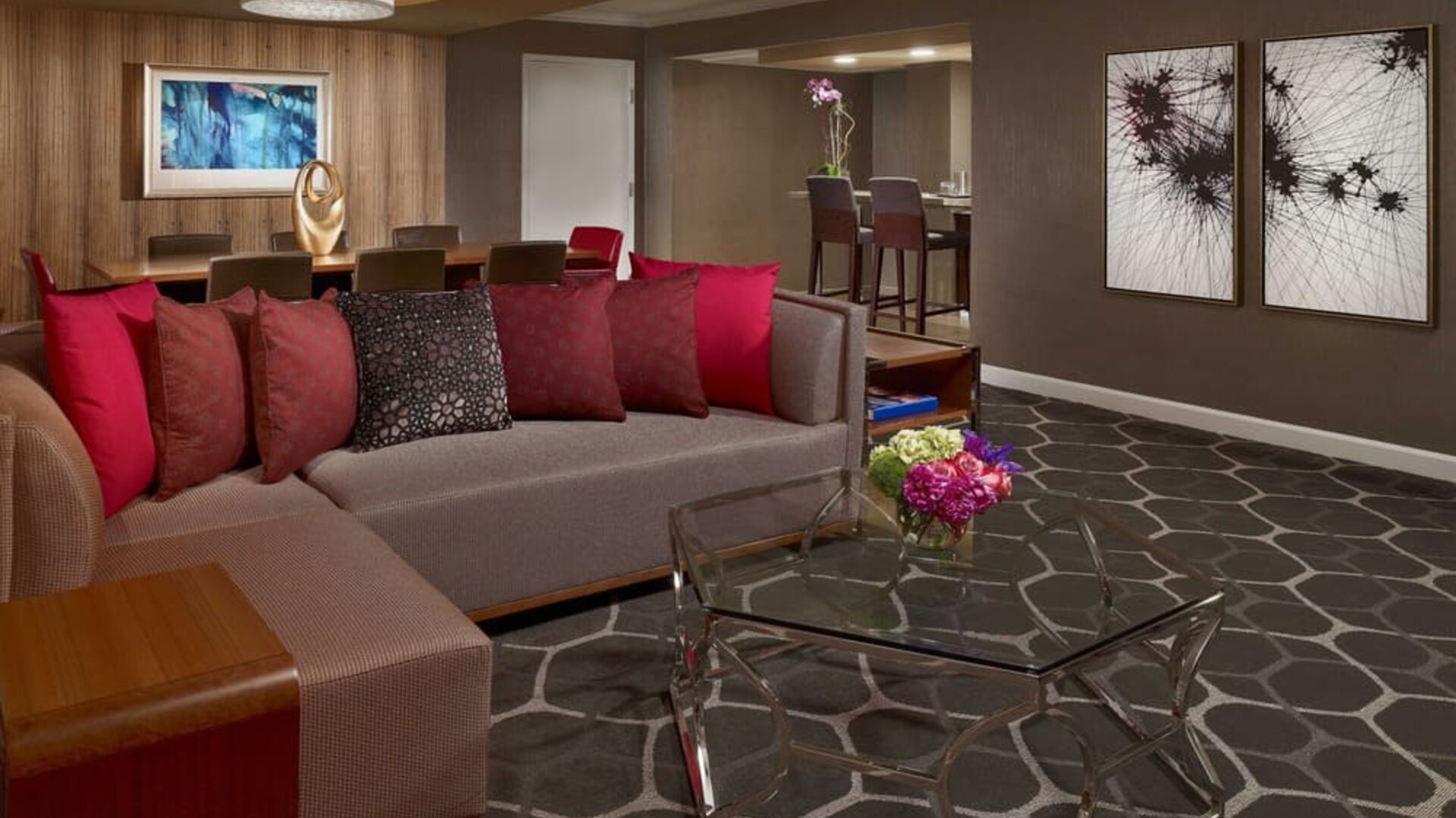 Royal Sonesta Houston Galleria workspace, featuring corner sofa and coffee table, plus long table surrounded by chairs.