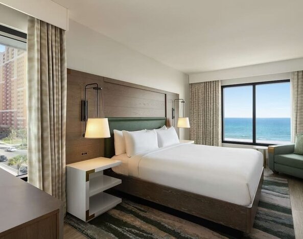 Day use room with king bed and sea view at Embassy Suites By Hilton Panama City Beach Resort.