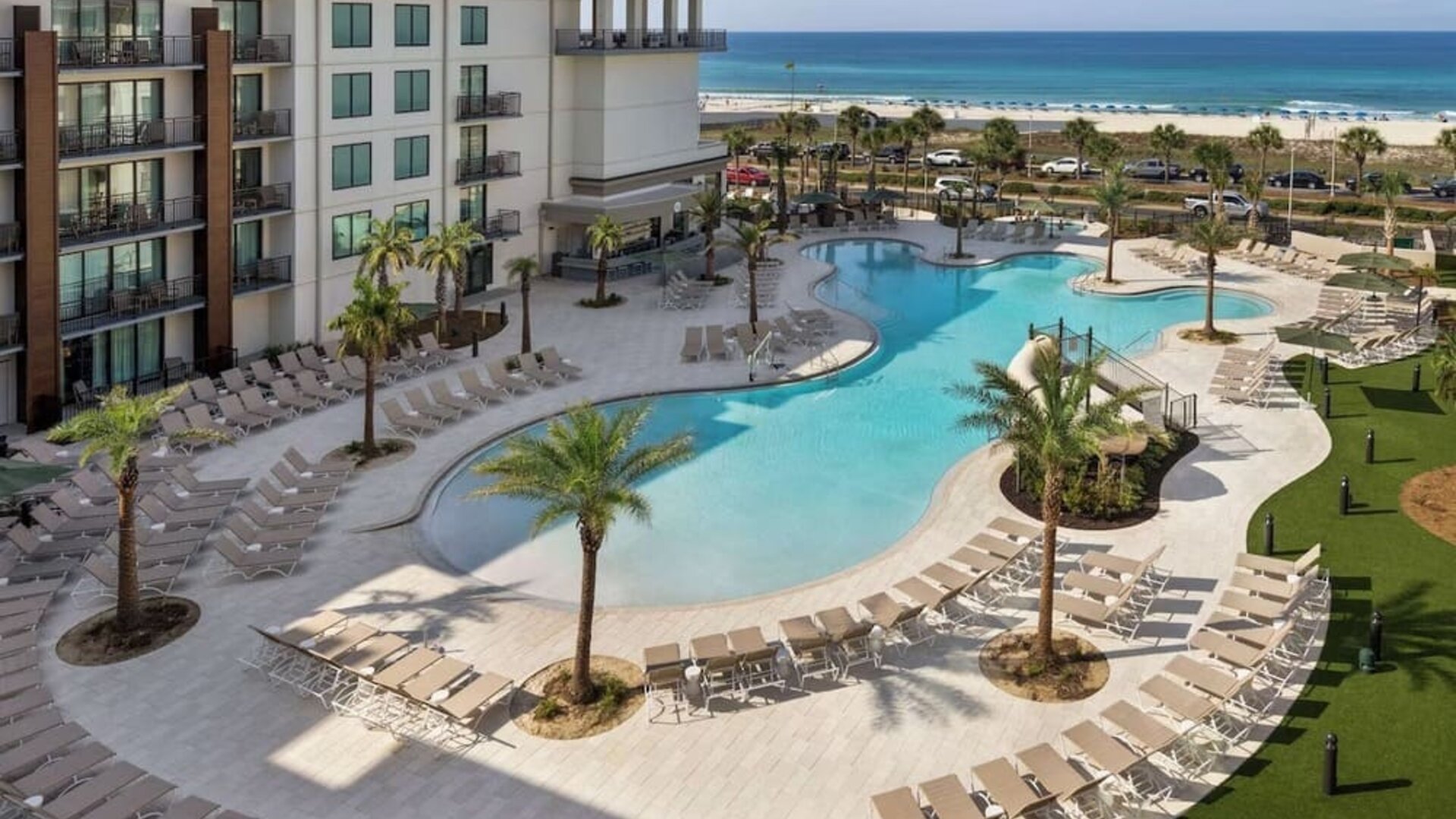 Beautiful outdoor pool with lounge chairs at Embassy Suites By Hilton Panama City Beach Resort.