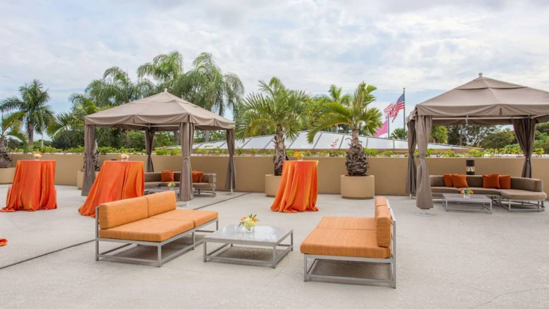 The hotel’s patio has comfortable sofa seating, coffee tables, and potted palm trees.