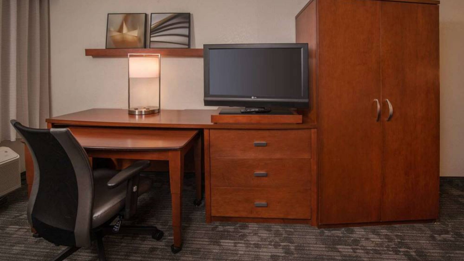 Sonesta Select Arlington Rosslyn guest room workspace, including desk, chair, lamp, and TV.