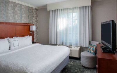 Double bed guest room in Sonesta Select Boston Lowell Chelmsford, including window and television.