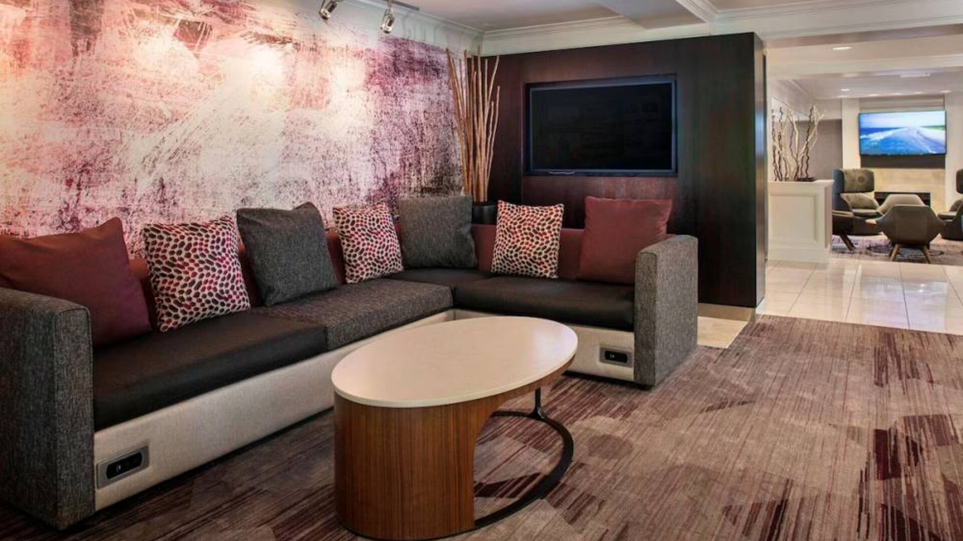 The hotel’s lobby has comfortable sofa seating, a coffee table, and large widescreen television.