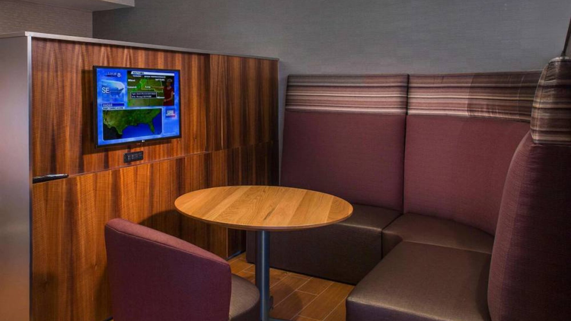 A media pod, featuring coffee table, TV, and comfortable seating where guests can relax and co-work.