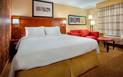 Double bed guest room in Sonesta Select Boston Danvers, furnished with sofa and coffee table.