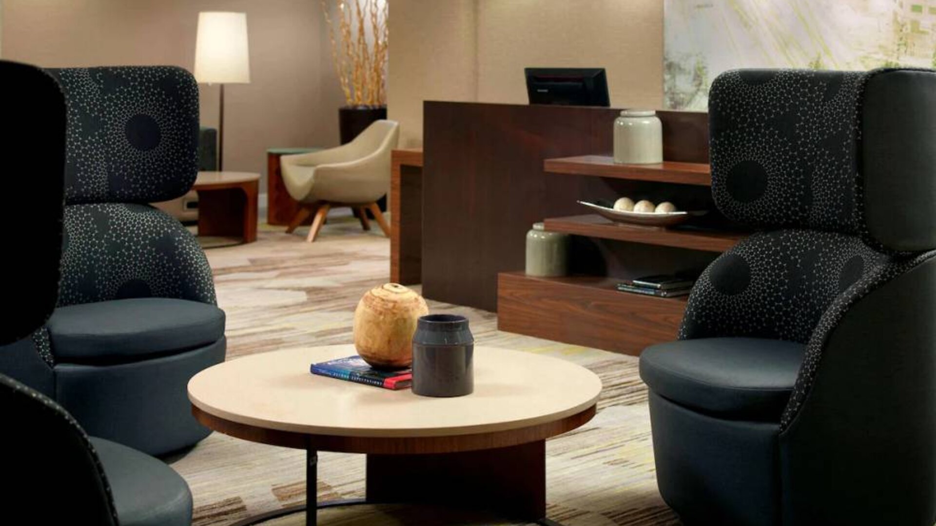 Sonesta Select Atlanta Cumberland Galleria’s lobby lounge is furnished with comfortable chairs and coffee tables.